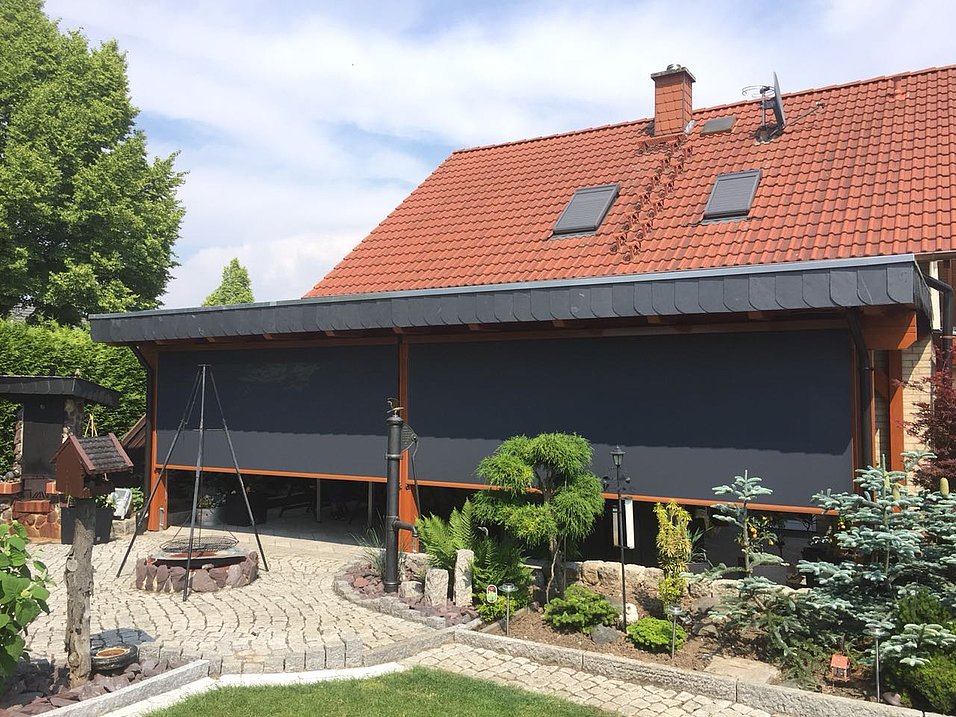 Senkrechtmarkise unter einem überdachten Terrassenbereich am Wohnhaus